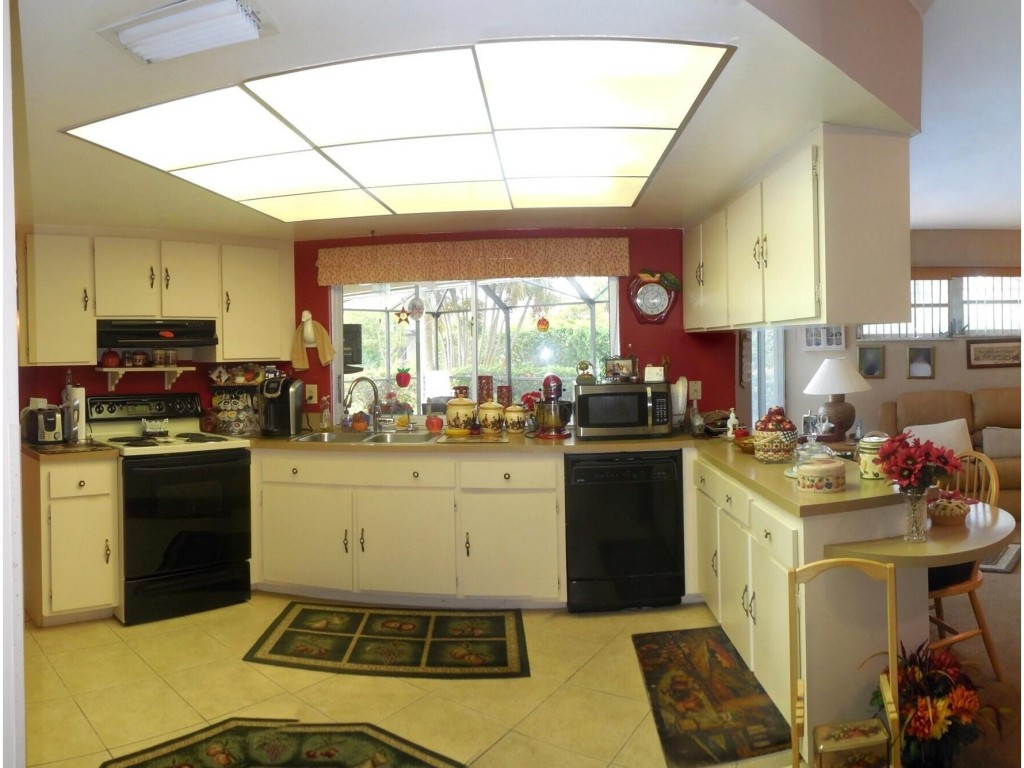 4517 Parrot Avenue Naples, FL 34104 - Photo 9 of 13 a kitchen with a sink appliances cabinets and a large window