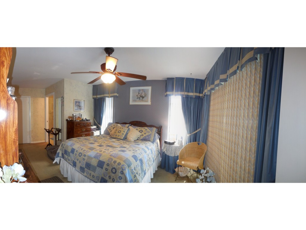 4517 Parrot Avenue Naples, FL 34104 - Photo 10 of 13 a bedroom with a bed and a chandelier