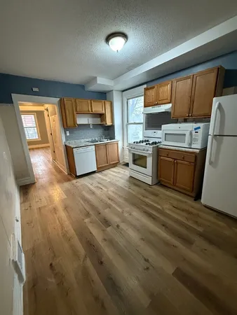 a kitchen with stainless steel appliances kitchen island granite countertop a sink dishwasher stove and refrigerator