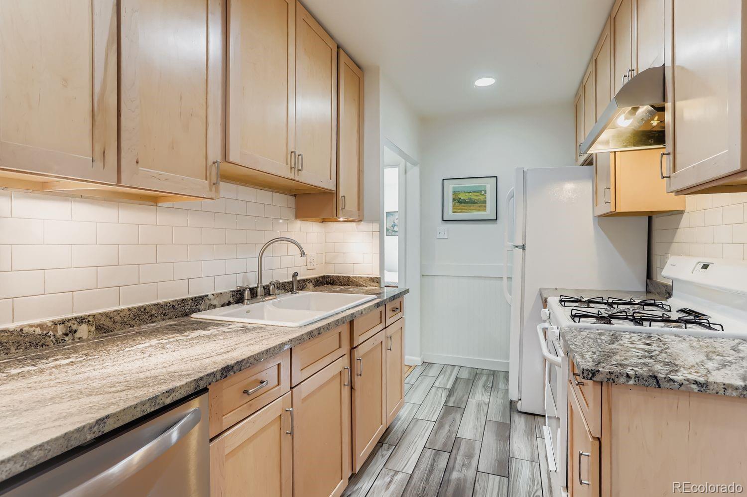 1010 9th Street Boulder, CO 80302 - Photo 11 of 28 a kitchen with granite countertop a sink stove and cabinets