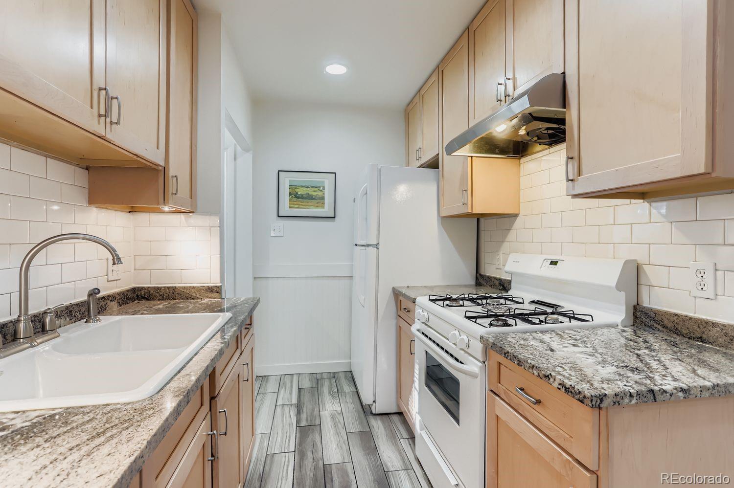 1010 9th Street Boulder, CO 80302 - Photo 12 of 28 a kitchen with granite countertop a sink stove and cabinets