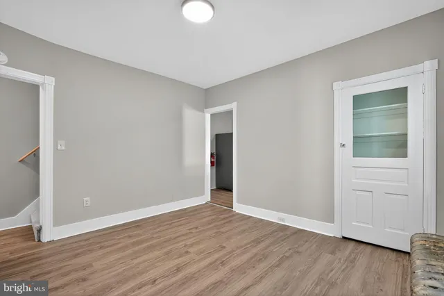 an empty room with wooden floor and closet