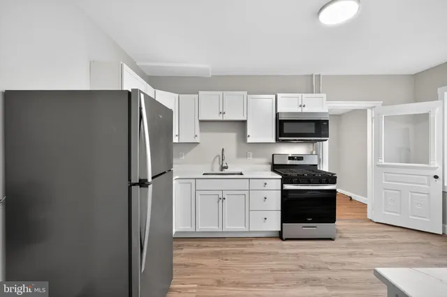 a kitchen with stainless steel appliances granite countertop a refrigerator stove and sink