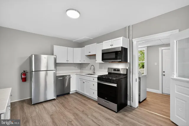 a kitchen with stainless steel appliances a refrigerator stove and wooden floor