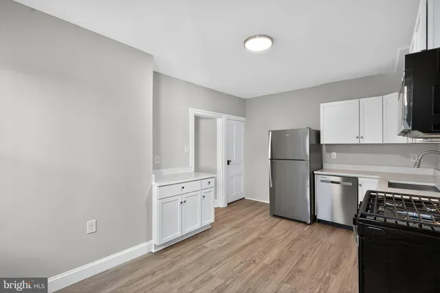 a kitchen with a refrigerator stove and wooden cabinets