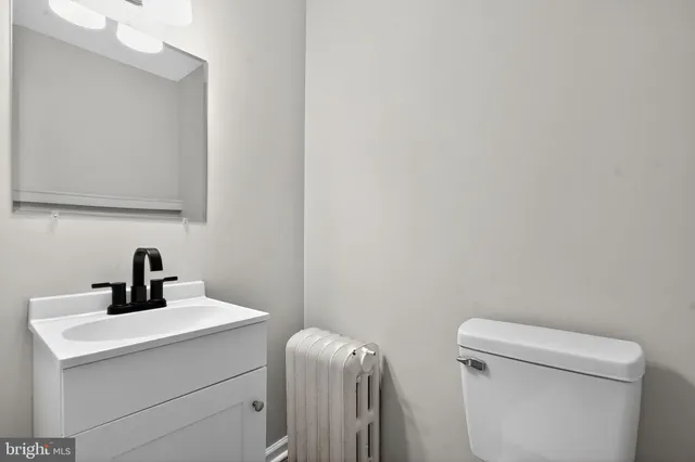 a bathroom with a toilet a sink and mirror