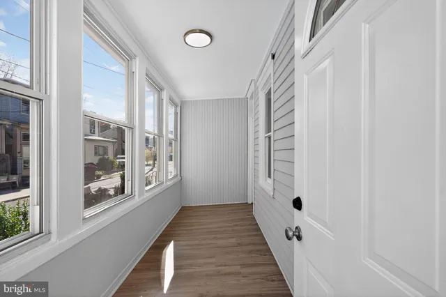 a view of a hallway with wooden floor and windows