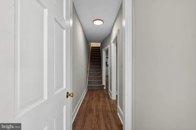 a view of a hallway with wooden floor and staircase