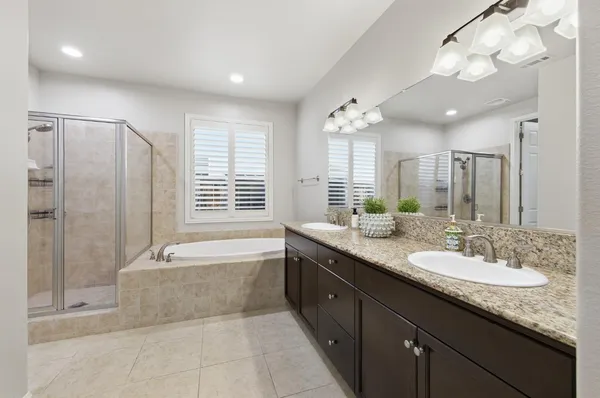 a bed sitting in a spacious bedroom next to a window