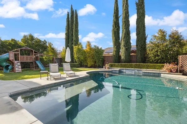 a view of a house with backyard and sitting area