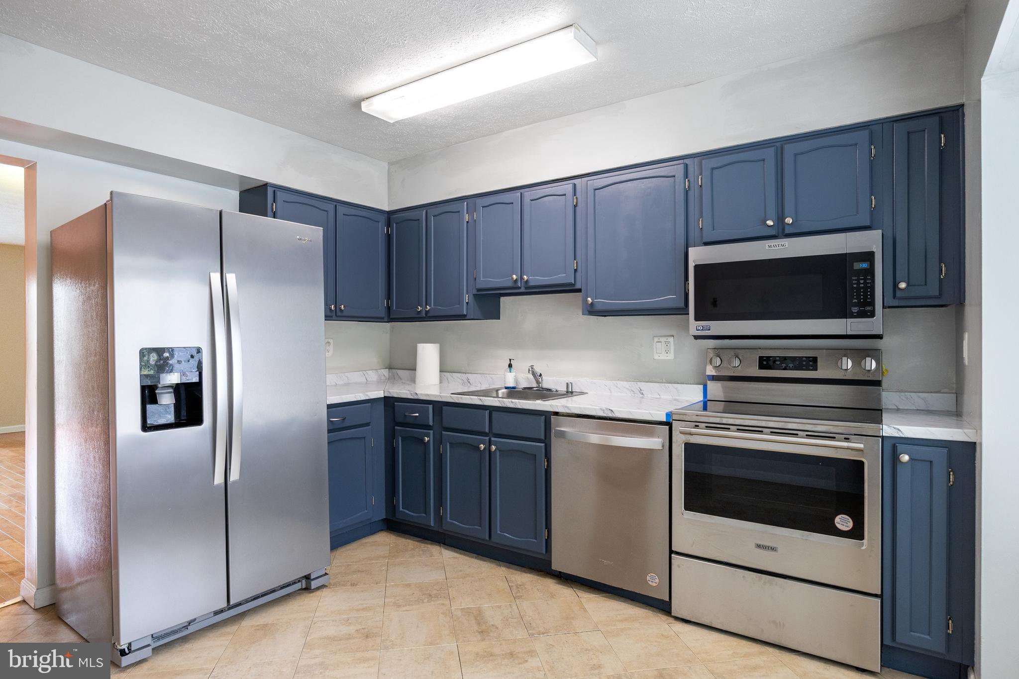 13 Sylvanhurst Court Baltimore, MD 21236 - Photo 5 of 35 a kitchen with stainless steel appliances granite countertop a stove a refrigerator and a microwave