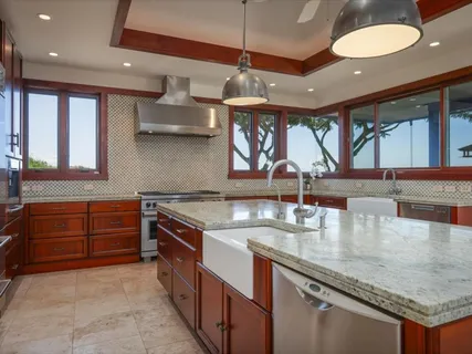 a kitchen with stainless steel appliances granite countertop a sink a stove and a wooden floors