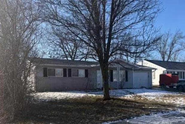 a view of a house with a yard covered in snow