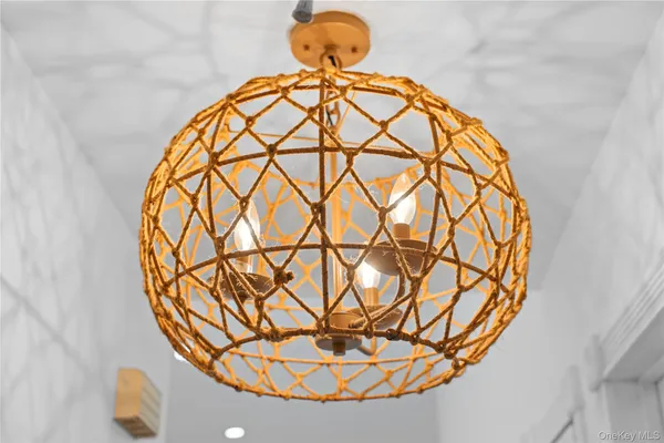 a view of a room with a chandelier and wooden floor