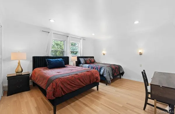 a bedroom with two beds and a chair