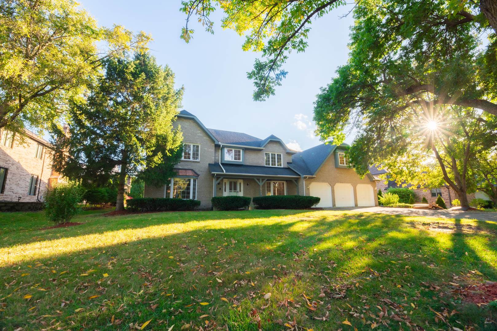a view of a house with a big yard and large trees