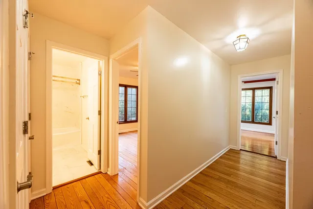 a view of a room with wooden floor and a bathroom
