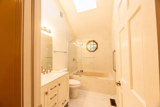 a bathroom with a granite countertop sink toilet and shower
