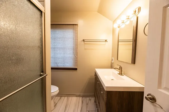 a bathroom with a sink a toilet and shower