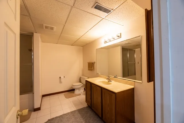 a bathroom with a sink mirror and a toilet