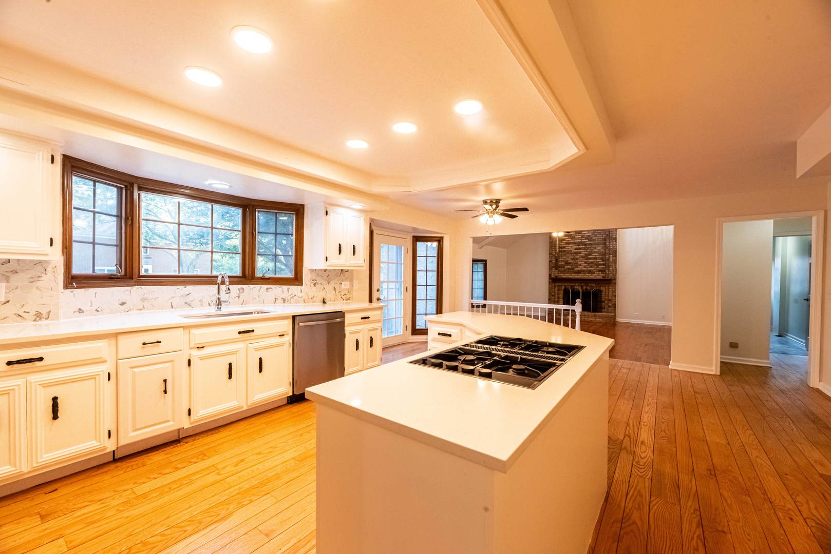 3021 35th Street Oak Brook, IL 60523 - Photo 10 of 32 a kitchen with stainless steel appliances kitchen island granite countertop a stove a sink dishwasher and white cabinets with wooden floor
