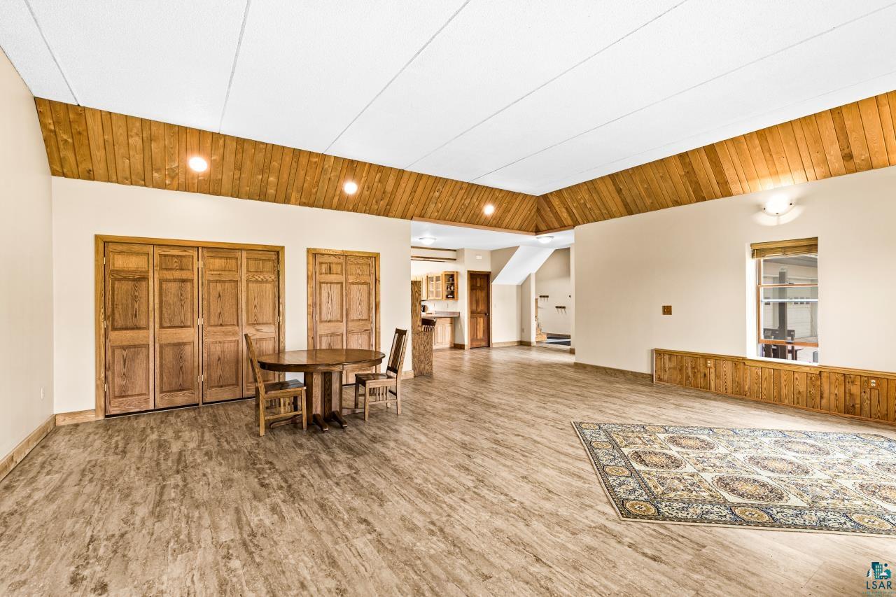 4800 Tower Road Moose Lake, MN 55767 - Photo 58 of 83 Spacious room featuring wood-finish flooring, a white acoustic panel ceiling, and wood-paneled accents