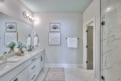 a bathroom with a granite countertop sink a mirror and a shower