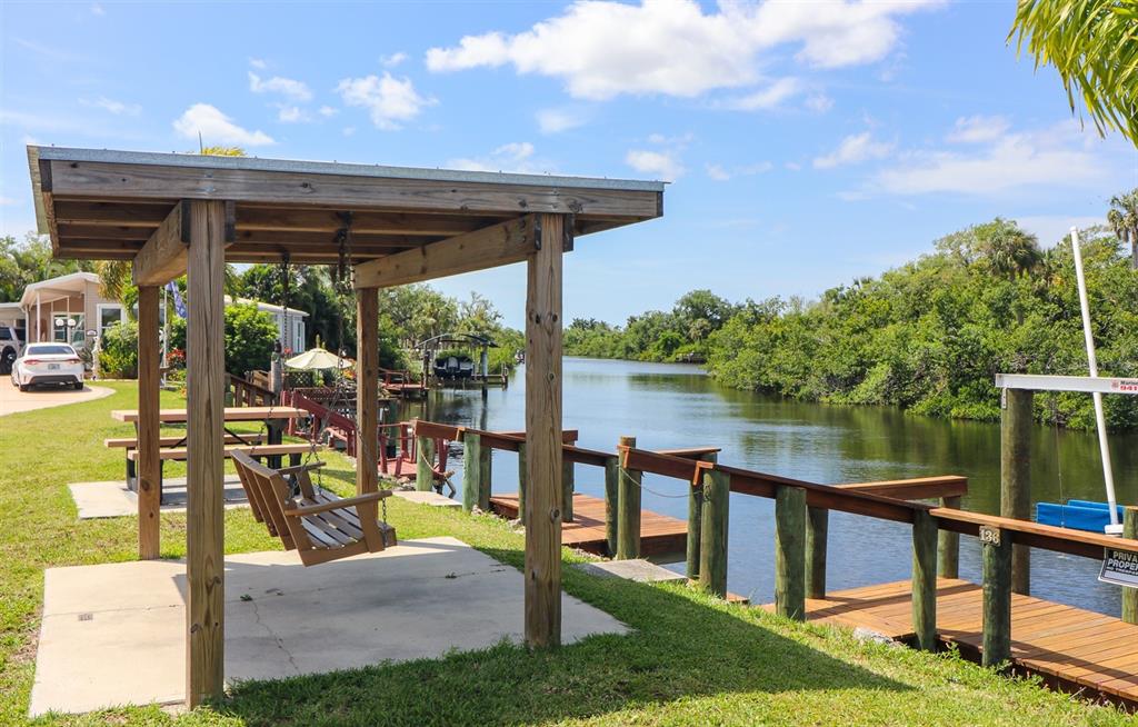 10101 Burnt Store Road, Unit 141 Punta Gorda, FL 33950 - Photo 33 of 34 a view of a patio with lawn chairs potted plants and a lake view