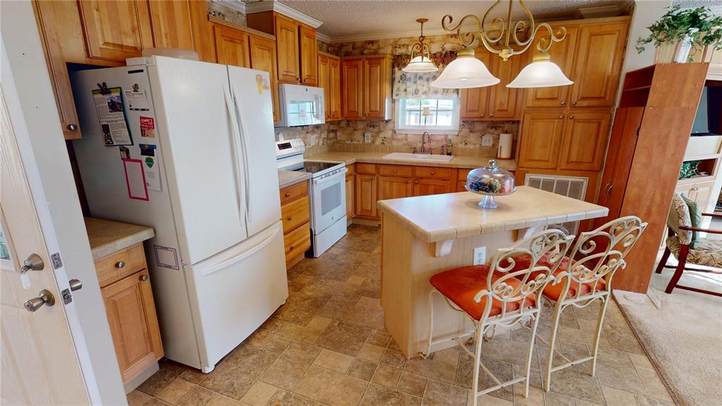 10101 Burnt Store Road, Unit 141 Punta Gorda, FL 33950 - Photo 9 of 34 a dining room with furniture a window and a refrigerator