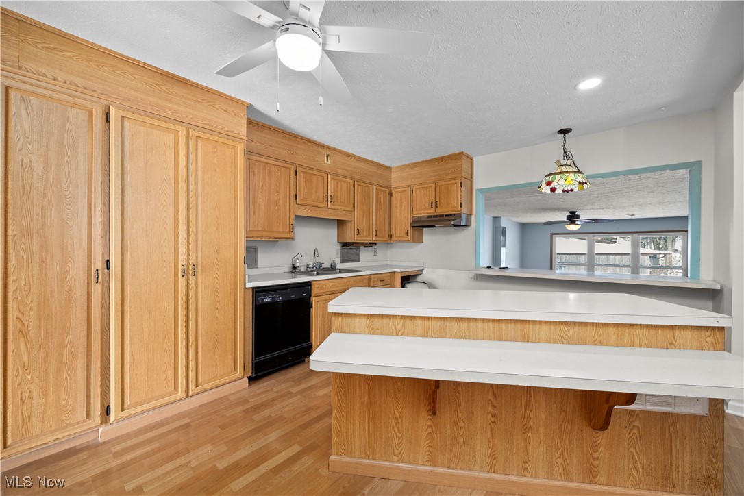 14015 West Lake Road Vermilion, OH 44089 - Photo 16 of 50 Kitchen featuring a ceiling fan, a textured ceiling, light countertops, pendant lighting, and a peninsula