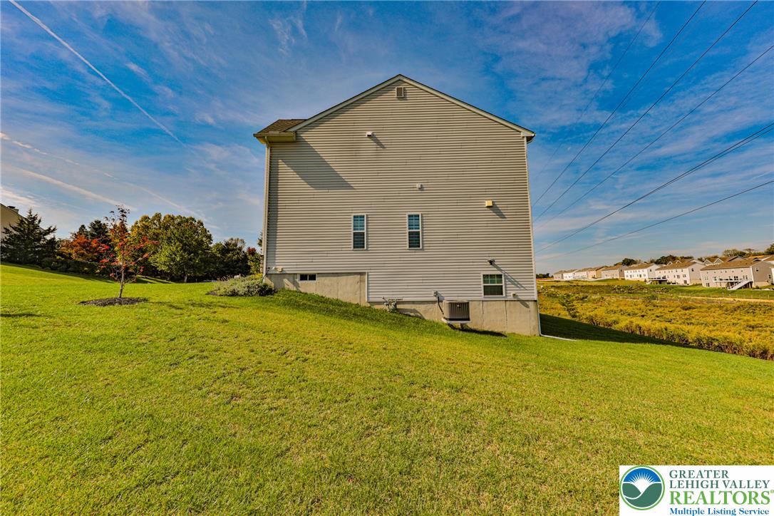 1105 Meco Road Easton, PA 18040 - Photo 90 of 100 A spacious grassy lawn slopes gently away from the classic light-colored siding of the home.