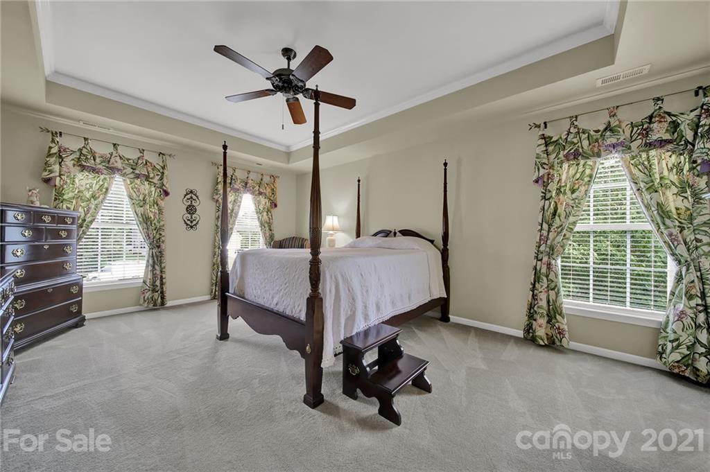 4509 Shadow Moss Circle Fort Mill, SC 29708 - Photo 13 of 43 a bedroom with a bed and a chandelier