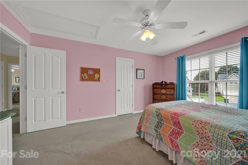 4509 Shadow Moss Circle Fort Mill, SC 29708 - Photo 19 of 43 a bedroom with a bed and a chandelier