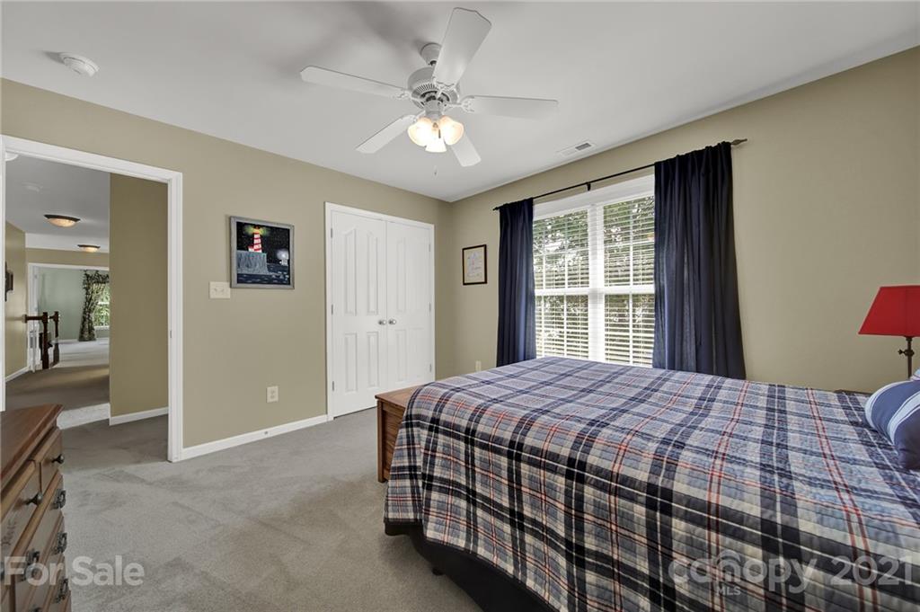 4509 Shadow Moss Circle Fort Mill, SC 29708 - Photo 27 of 43 a bedroom with a large bed and a chandelier