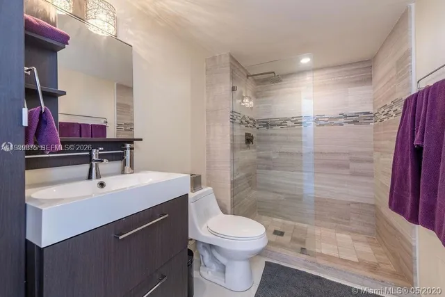 a bathroom with a sink toilet a mirror and shower