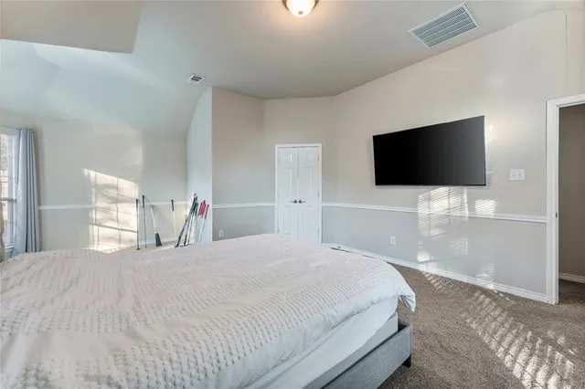 a bedroom with a bed and a flat screen tv