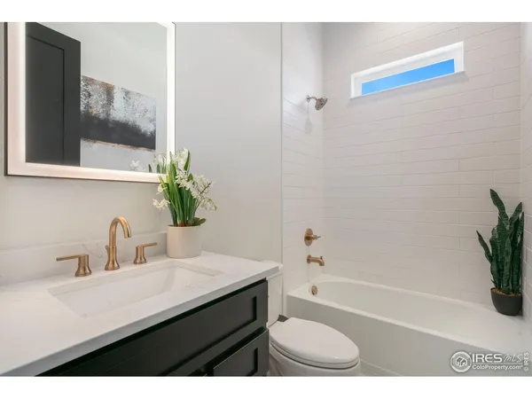 a bathroom with a sink a bathtub a mirror and shower