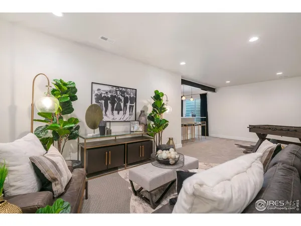 a living room with furniture flowerpot and a chandelier