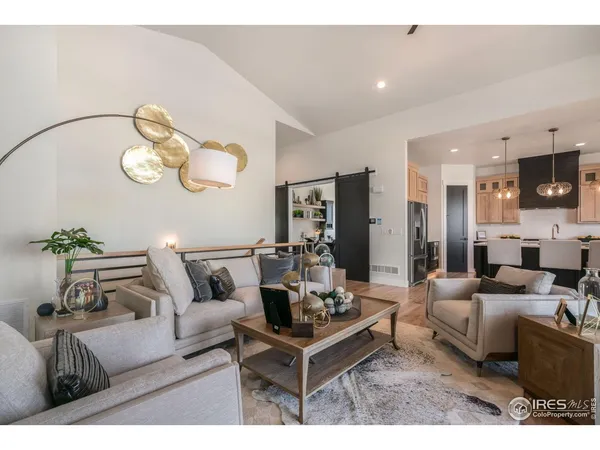 a living room with furniture kitchen view and a chandelier