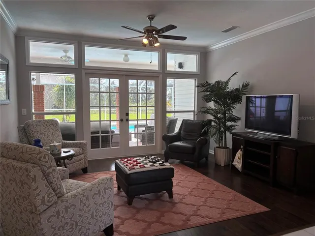 a dining room with furniture a mirror a chandelier and wooden floor