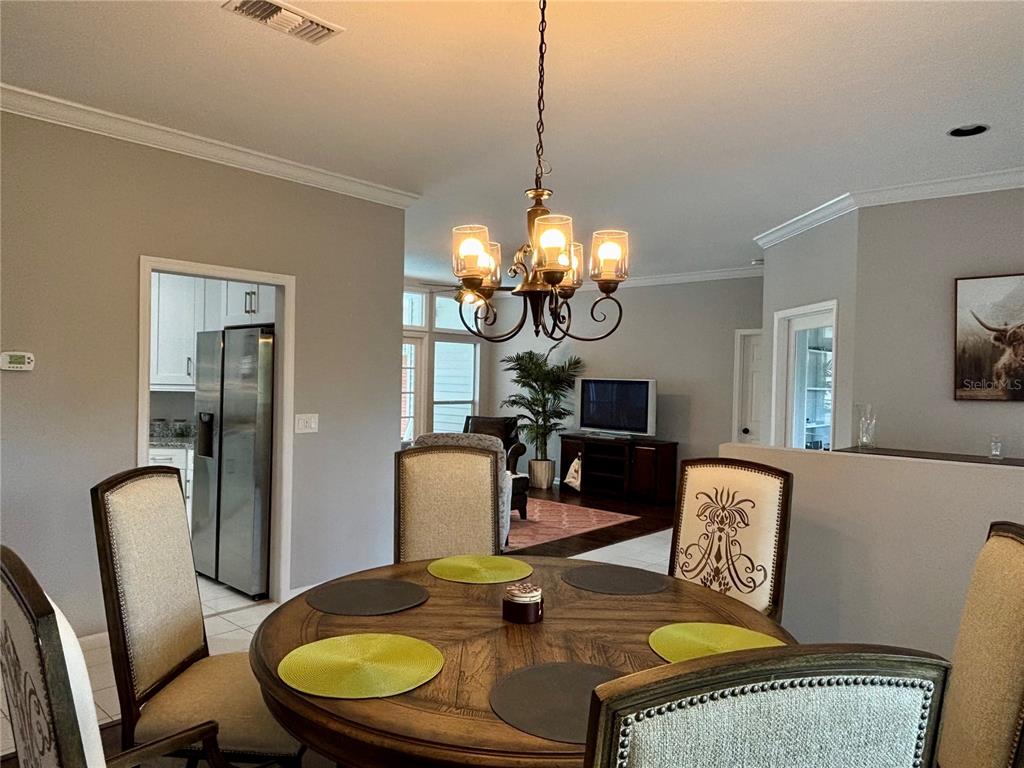 1950 Bern Creek Loop Sarasota, FL 34240 - Photo 19 of 60 a dining room with furniture a mirror a chandelier and wooden floor