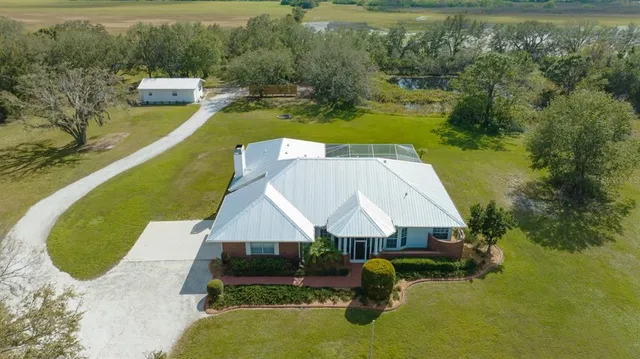 an aerial view of a house with swimming pool and lake view