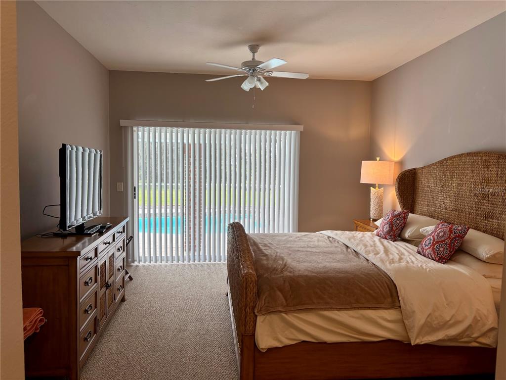 1950 Bern Creek Loop Sarasota, FL 34240 - Photo 24 of 60 a bedroom with a bed tv and a chandelier