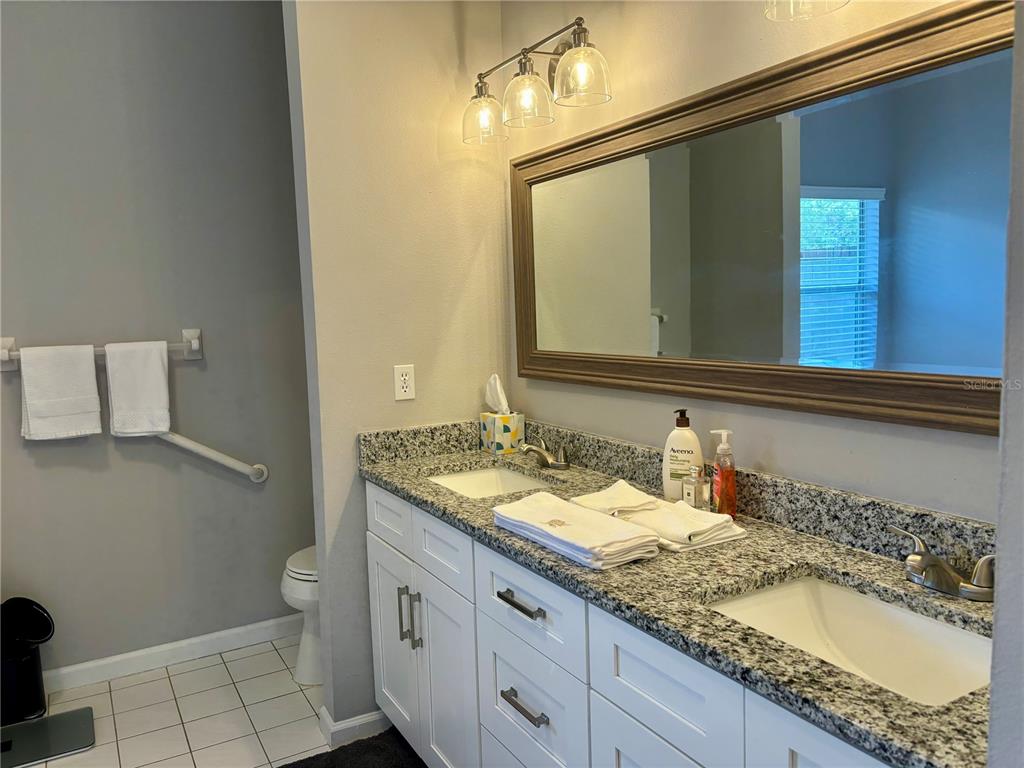 1950 Bern Creek Loop Sarasota, FL 34240 - Photo 26 of 60 a bathroom with a granite countertop sink and a mirror