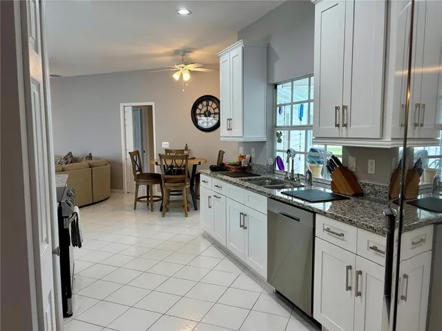 a living room with furniture kitchen view and a large window