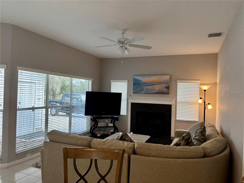 1950 Bern Creek Loop Sarasota, FL 34240 - Photo 36 of 60 a living room with furniture a fireplace and a flat screen tv