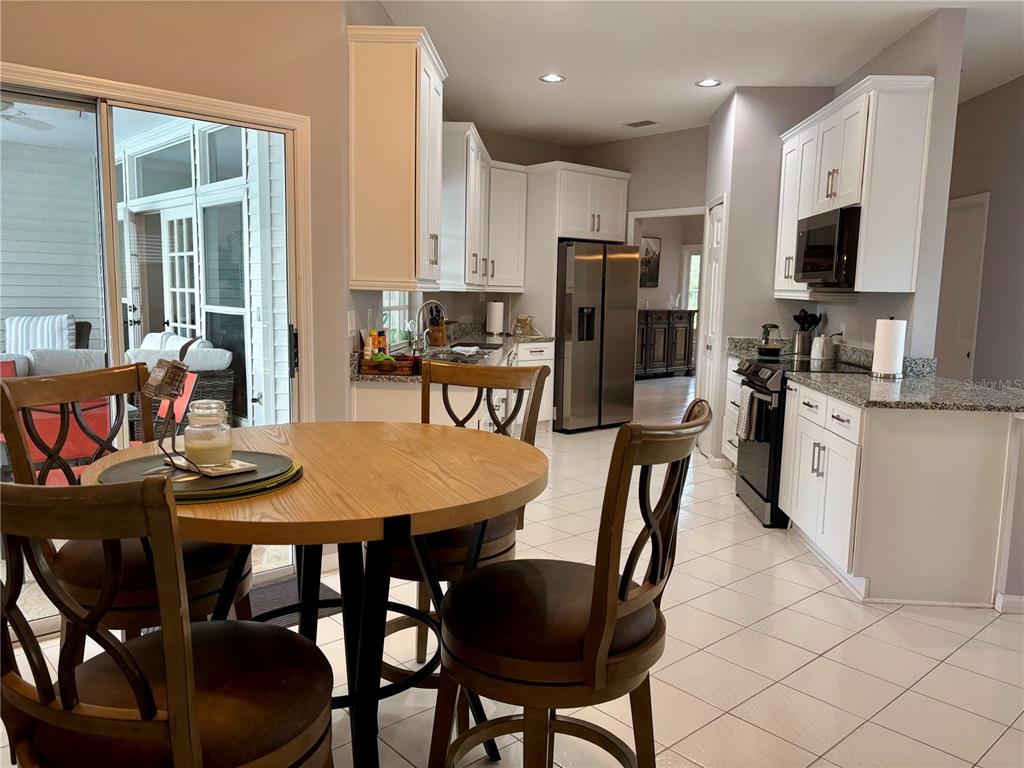 1950 Bern Creek Loop Sarasota, FL 34240 - Photo 38 of 60 a dining room with stainless steel appliances kitchen island granite countertop a dining table chairs and a refrigerator