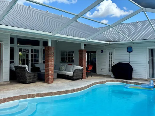 a view of backyard with table and chairs and a large tree