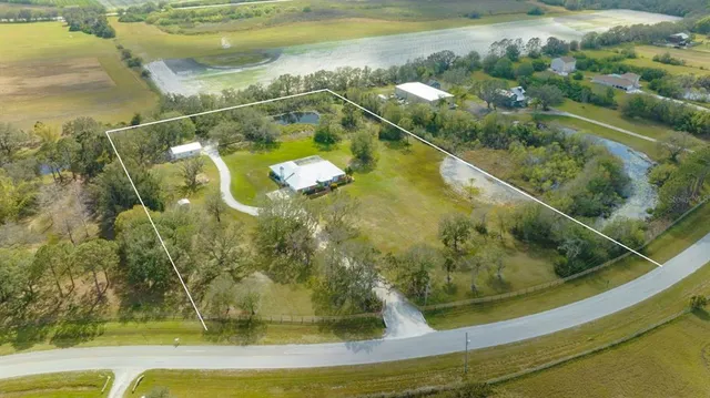 a aerial view of a residential houses with yard