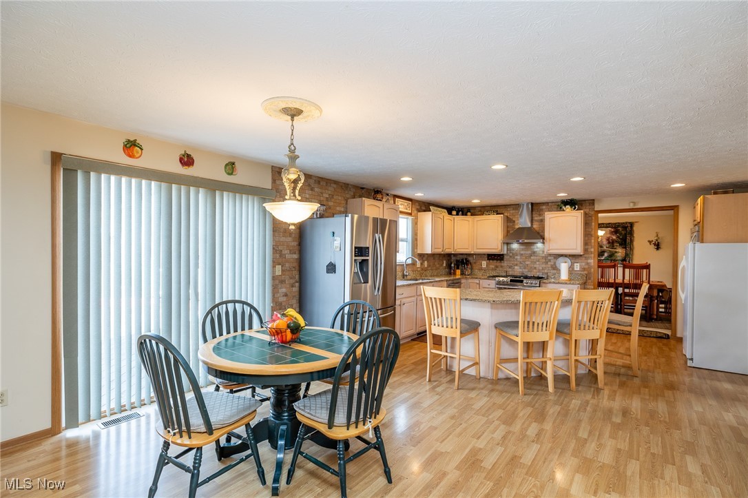 12181 Williams Road Homerville, OH 44235 - Photo 7 of 49 Dining room featuring sink, light hardwood / wood-style floors, and a wealth of natural light